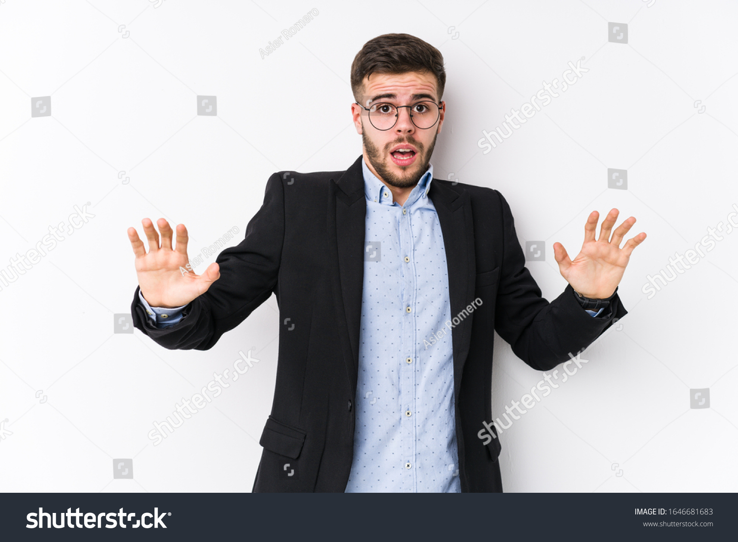 Young caucasian business man posing in a white background isolated Young caucasian business man being shocked due to an imminent danger #1646681683