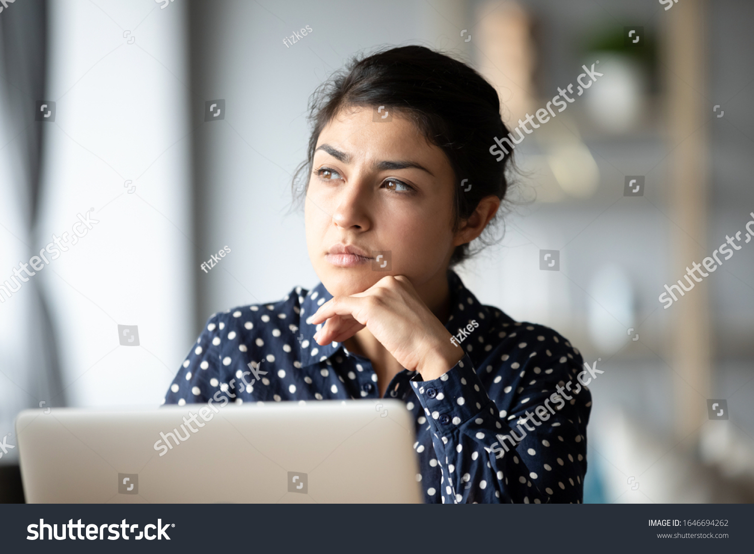 Pensive young ethnic woman distracted from computer work look in window distance thinking, thoughtful millennial Indian girl lost in thoughts pondering solving problem, making decision #1646694262