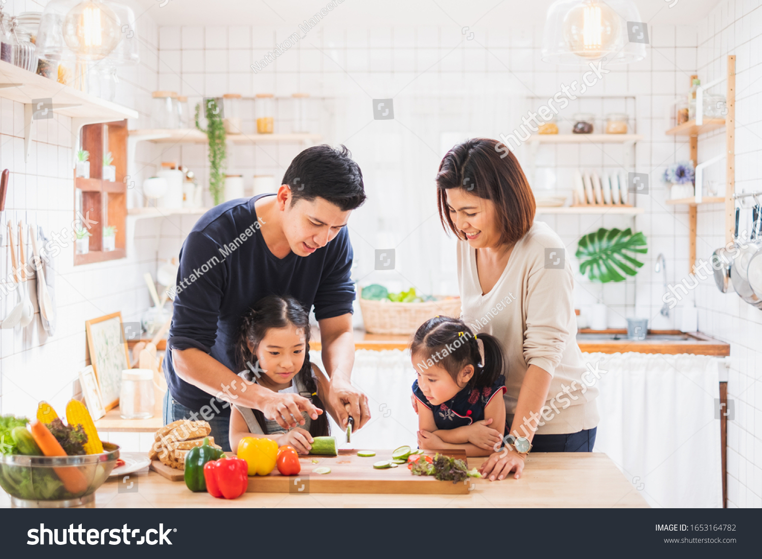 Asian family enjoy playing and cooking food in kitchen at home #1653164782
