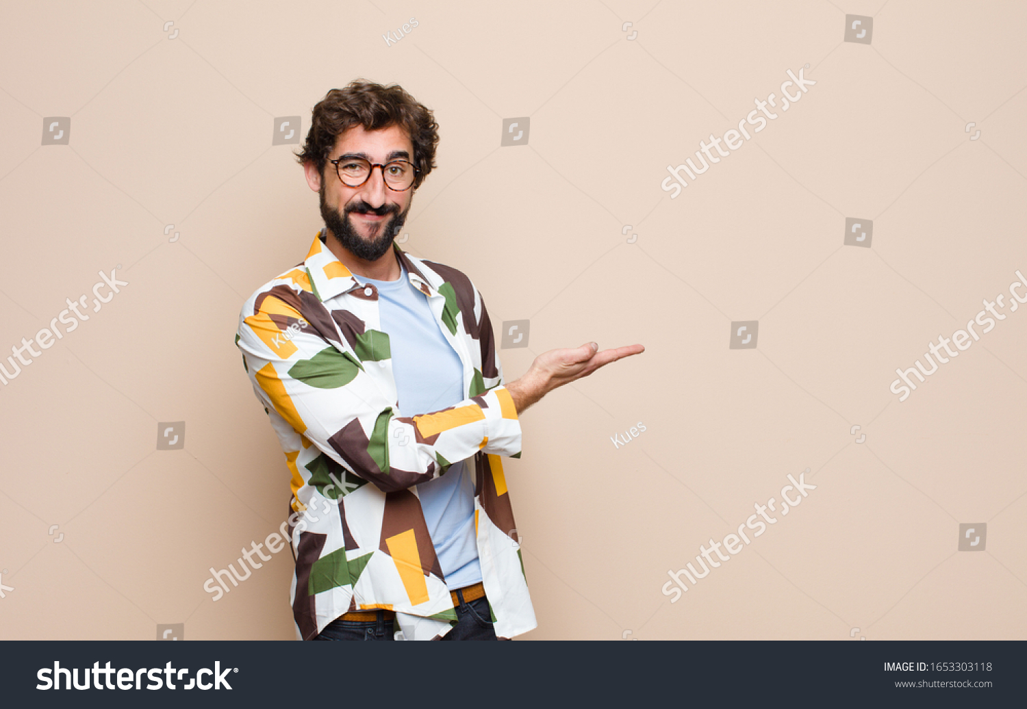 young cool bearded man expressing a concept against flat wall #1653303118