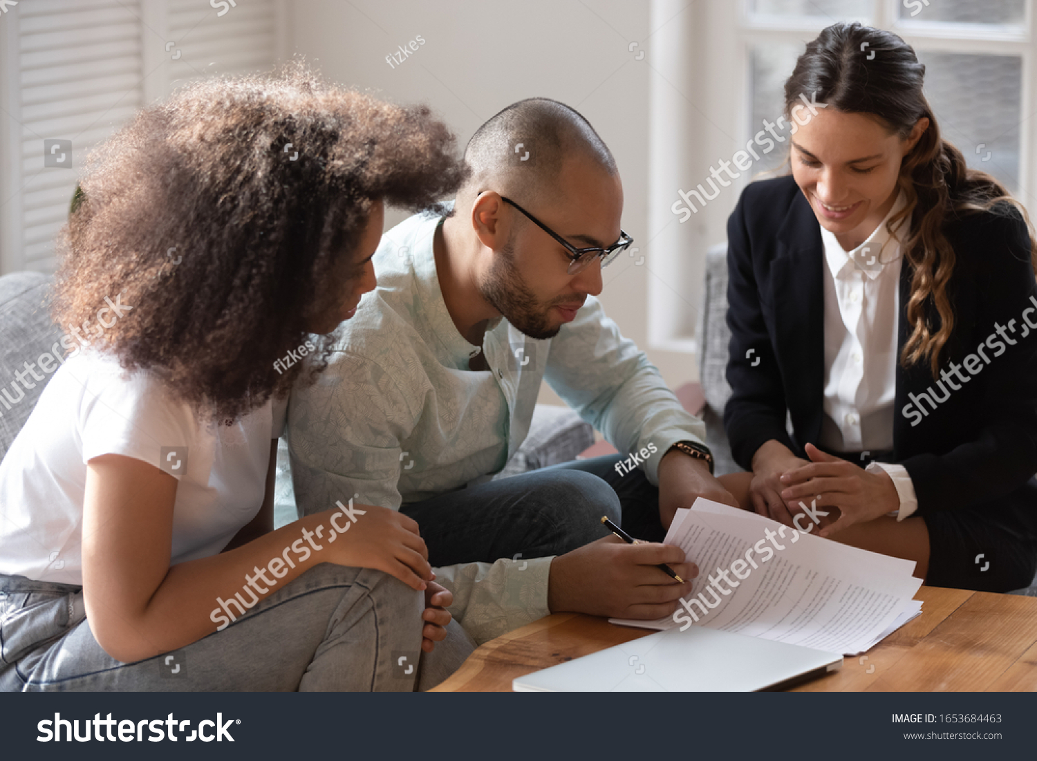 African couple meet with notary or lawyer discuss prenuptial agreement, before sign rental tenancy contract legal document pages spouses read conditions, banker and clients loan lease mortgage concept #1653684463