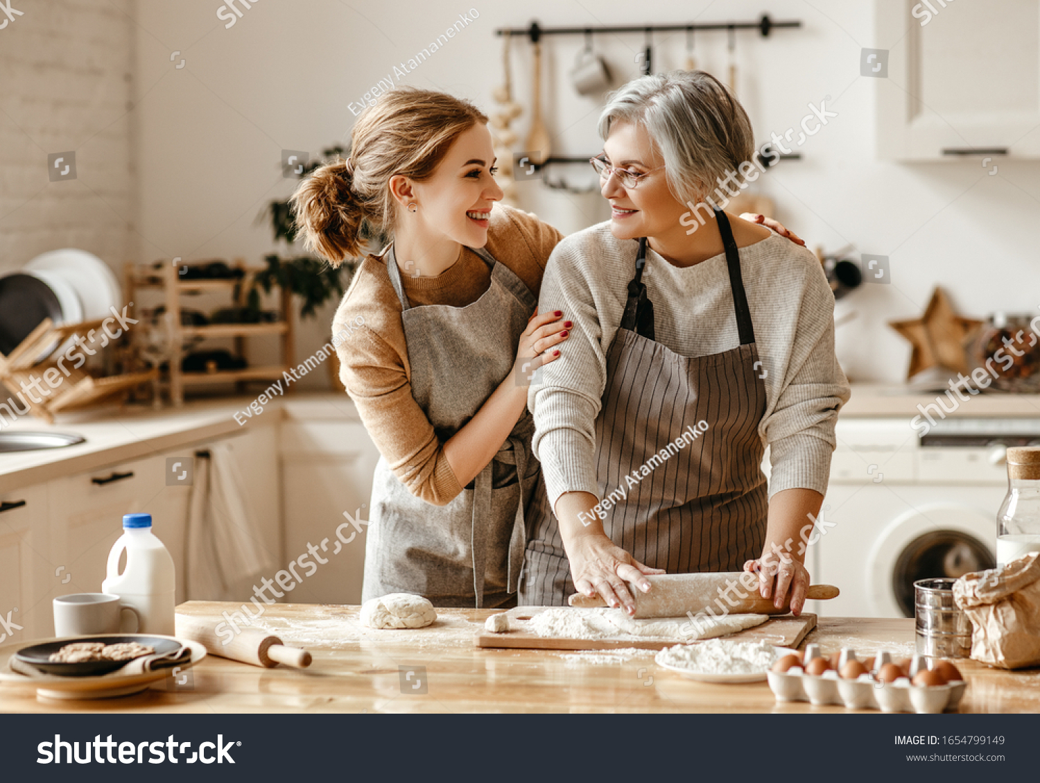 happy family grandmother  old mother mother-in-law and daughter-in-law daughter cook in kitchen, knead dough and bake cookies
 #1654799149