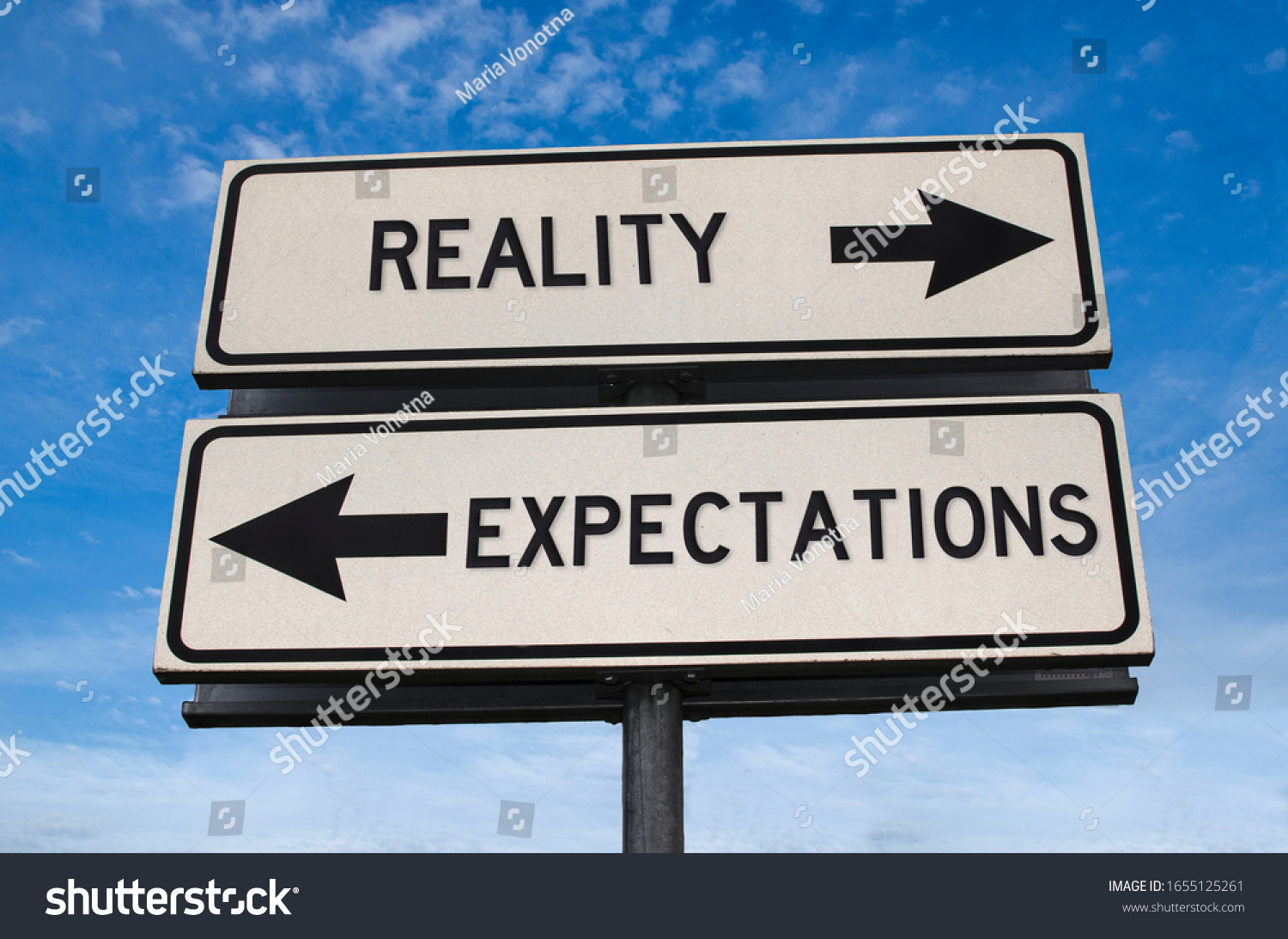 Reality vs expectation. White two street signs with arrow on metal pole with word. Directional road. Crossroads Road Sign, Two Arrow. Blue sky background. Two way road sign with text. #1655125261