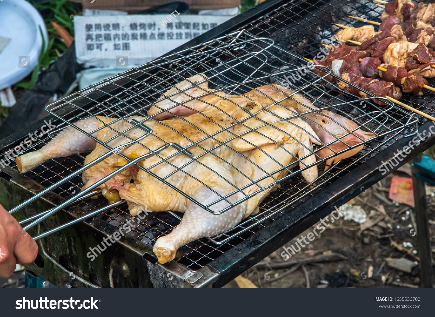 Barbecued fresh whole chicken outdoors in the forest #1655536702