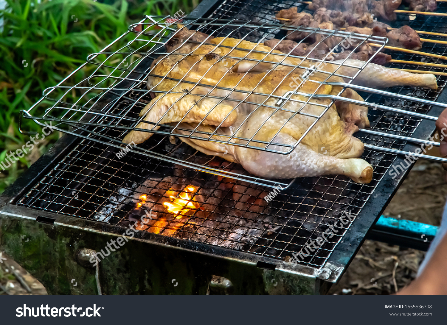 Barbecued fresh whole chicken outdoors in the forest #1655536708