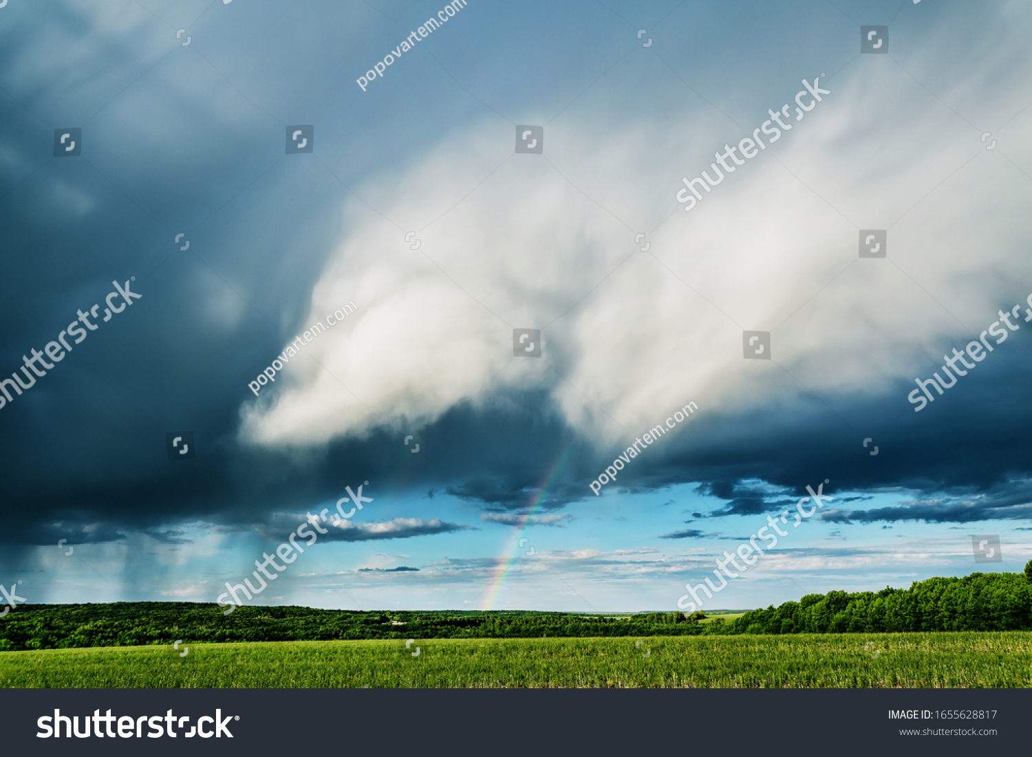 Nature background. Rainclouds and rain over the field with rainbow #1655628817