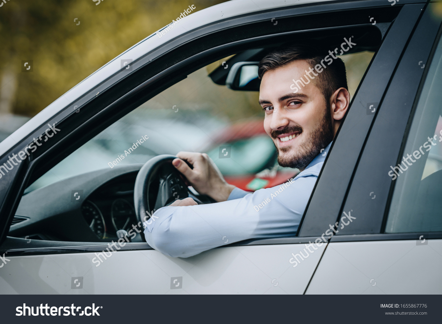 Young man driving a car smiling #1655867776