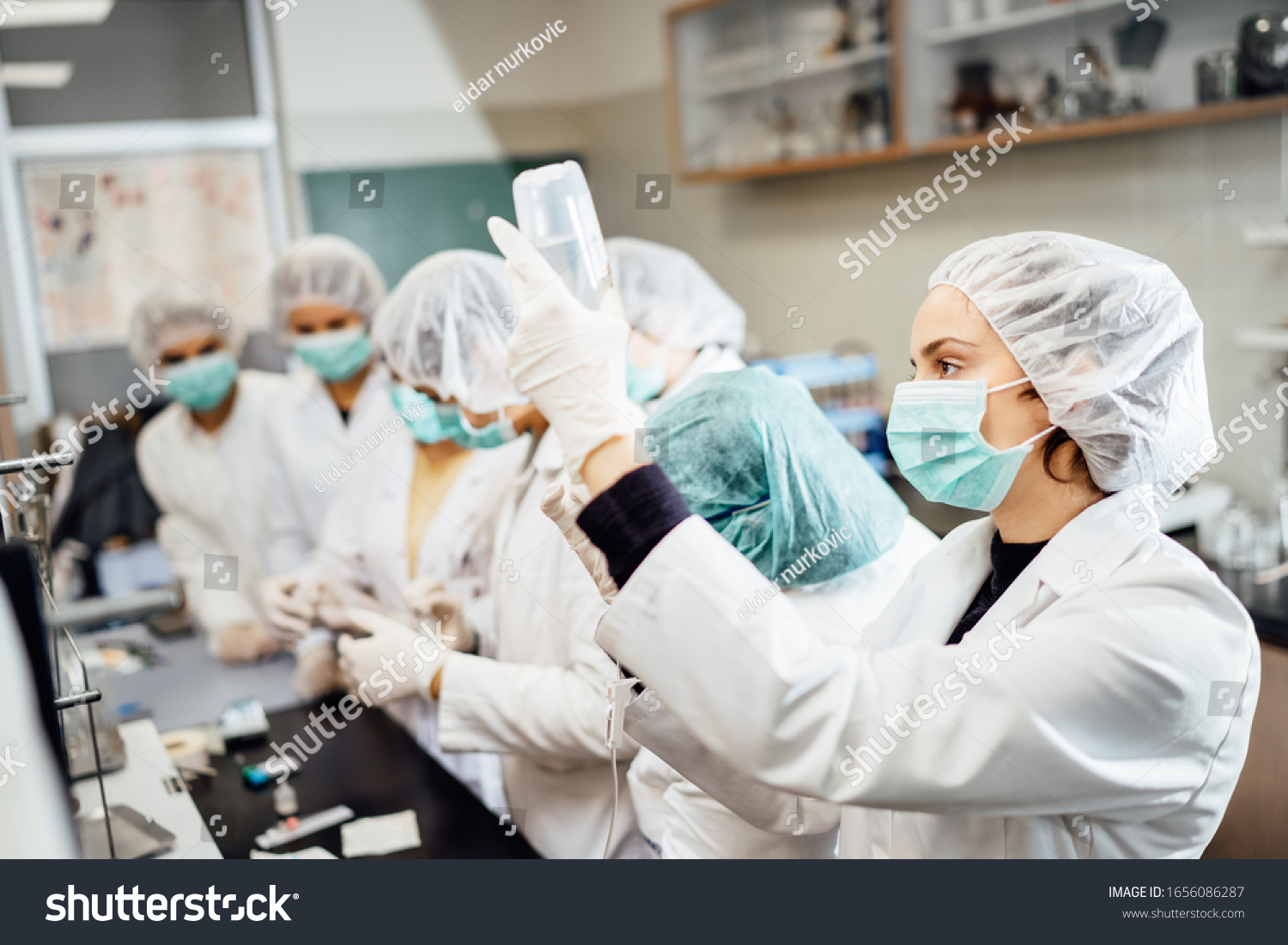 Team of pharmacists developing parenteral antibody antivirus.Pharmaceutical development of a new vaccine.Parenteral antibiotic safety control test examination in the cleanroom.Virus epidemic concept #1656086287