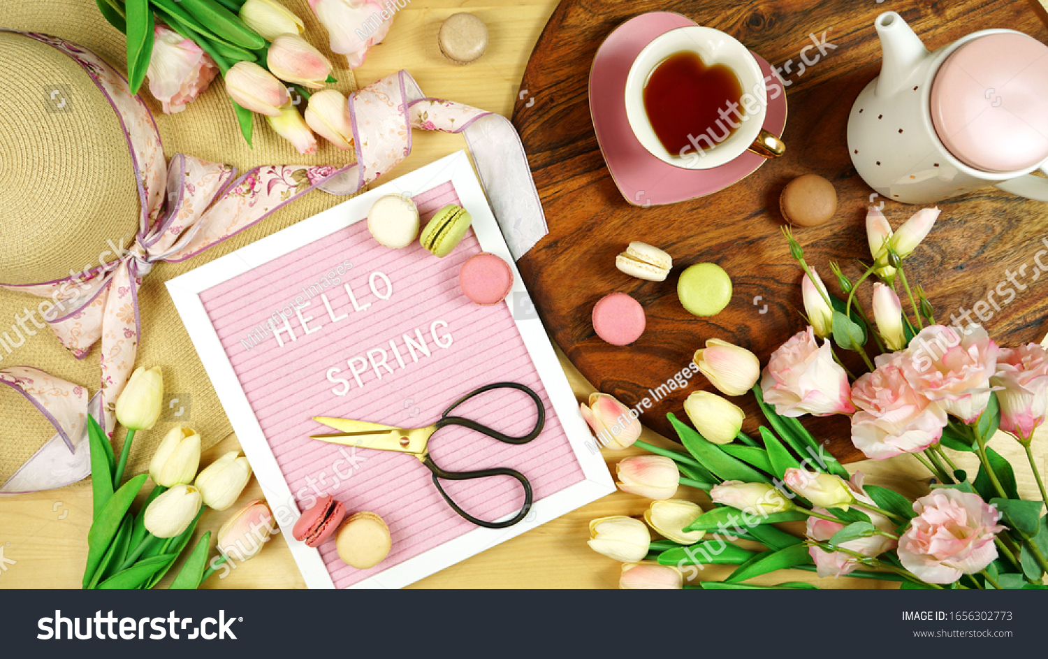 Hello Spring theme creative layout concept flat lay tea break with pink tulips and lisianthus flowers, sun hat on wooden table background, wih felt letter board. #1656302773
