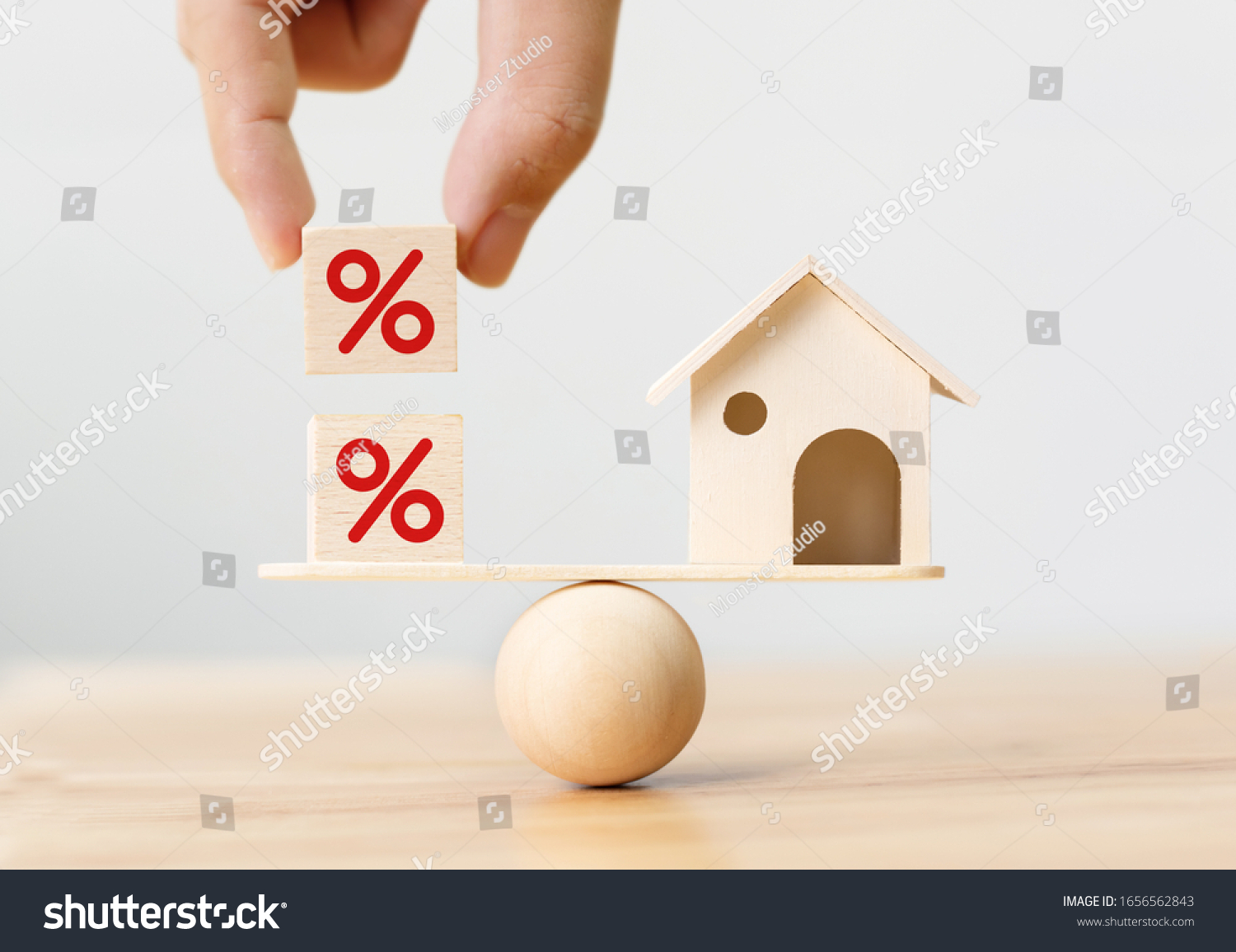 Interest rate financial and mortgage rates concept. Wooden home and hand putting cube block shape with icon percent on wood scales #1656562843