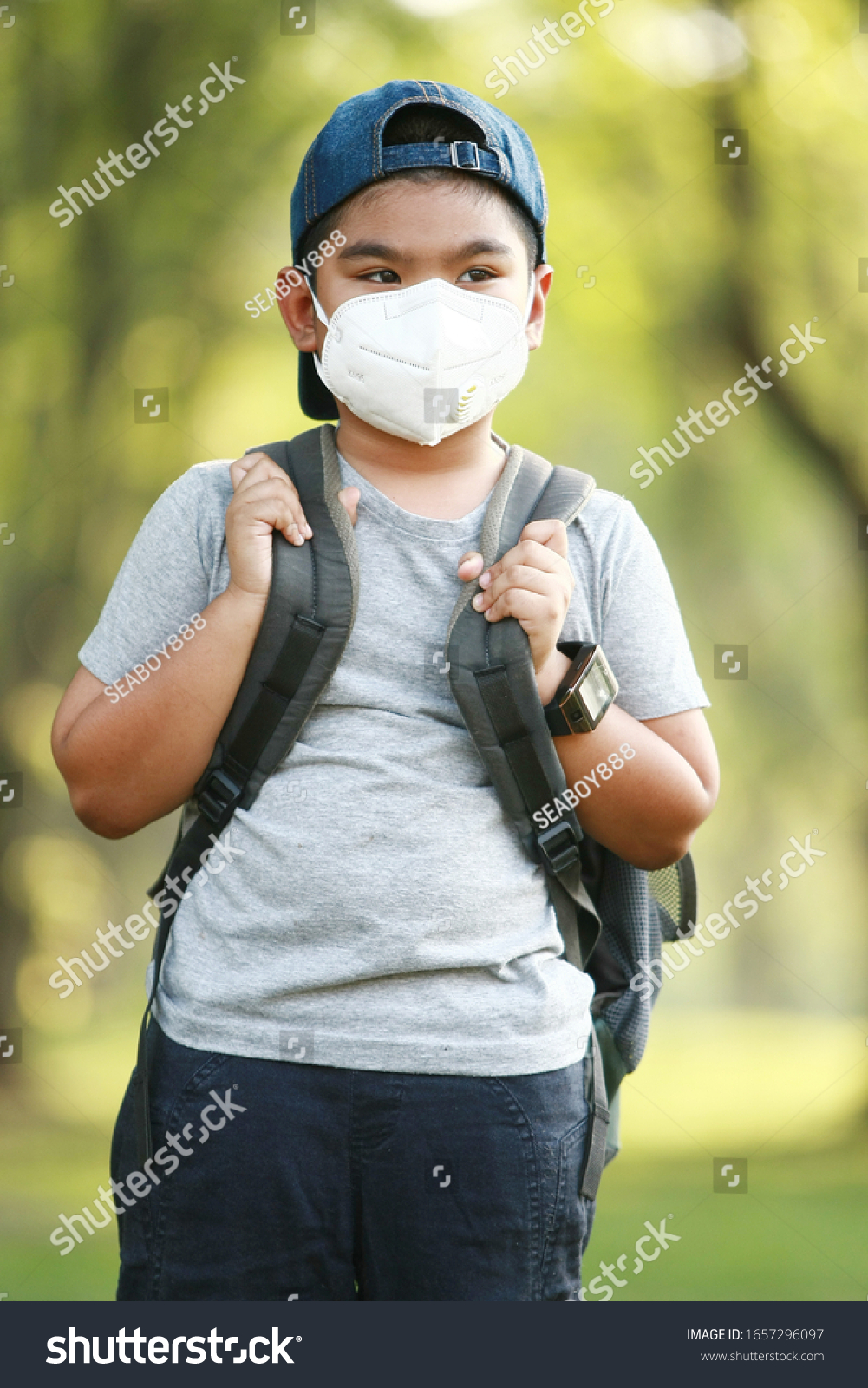 A young Asian boy , 7 Years Old , wear mask to protect against dust PM 2.5 and germs #1657296097