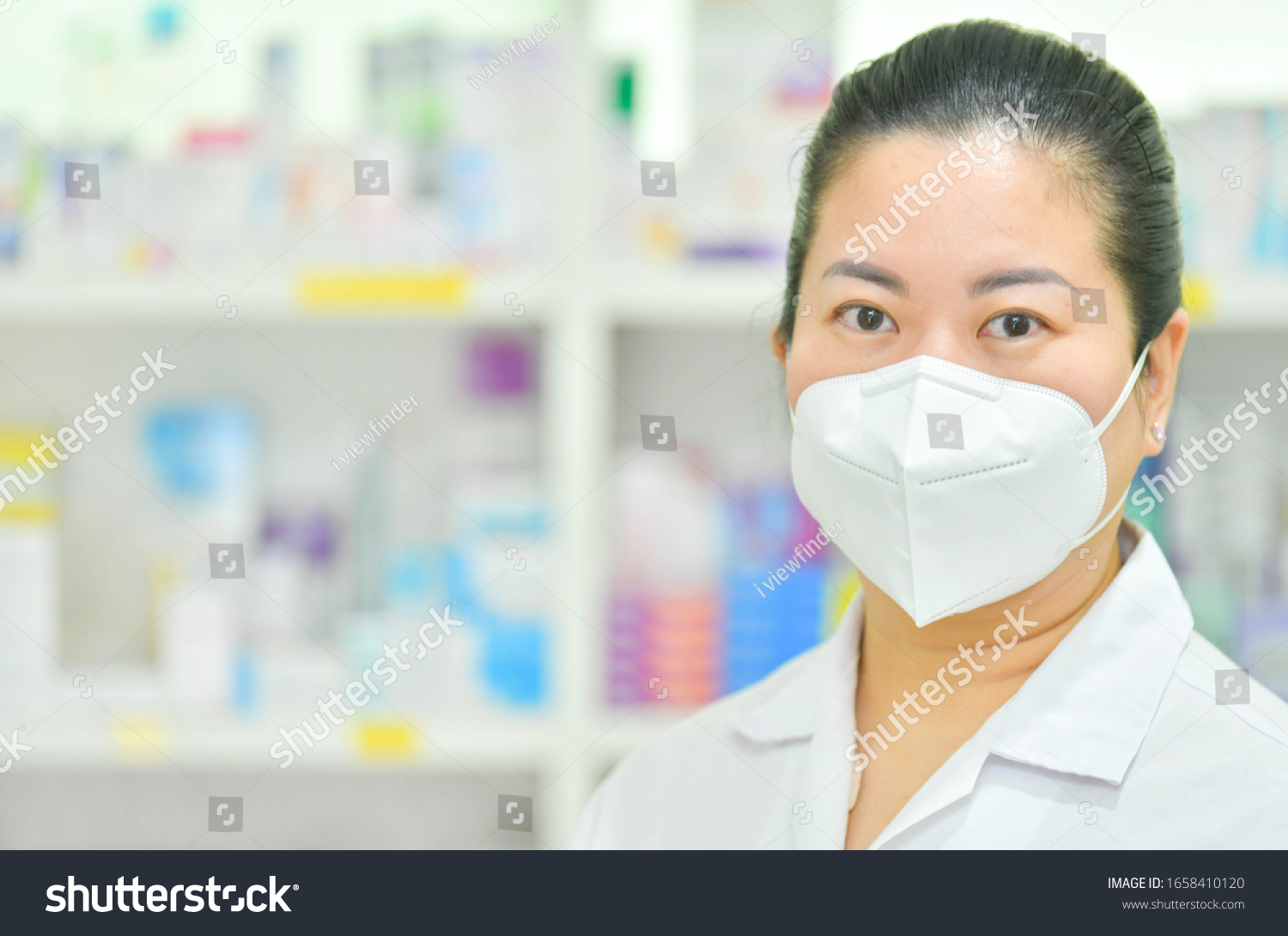 Portrait of young female doctor wear N95 mask on many medicine shelf background. Coronavirus (COVID-19)concept of disease, flu treatment and protection. #1658410120