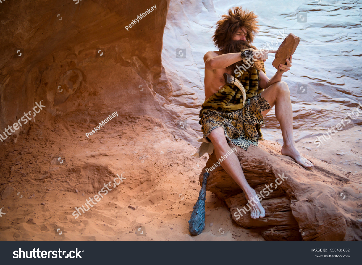 Caveman swiping his primitive touch screen stone tablet outdoors in a weathered rock cave #1658489662