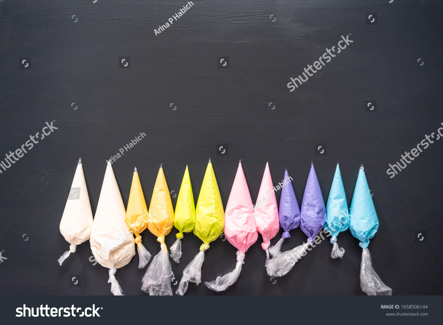 Flat lay. Variety of colors of royal icing in plastic piping bags. #1658506144