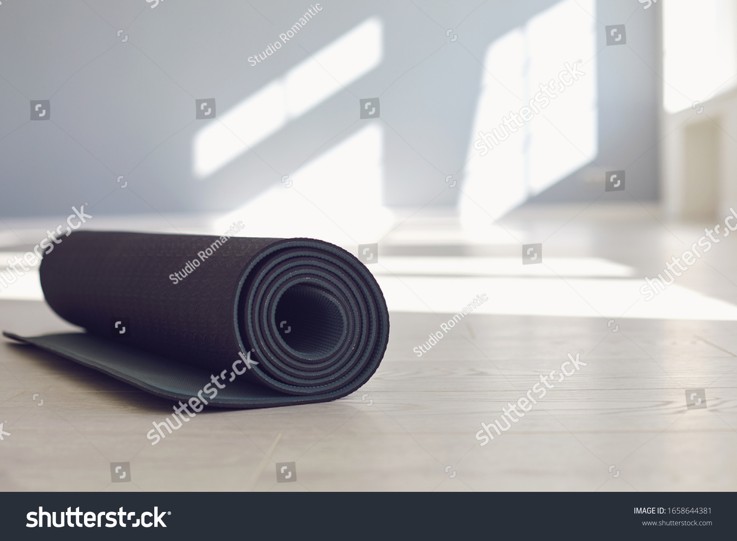Black yoga mat on the floor of a bright sunny studio. #1658644381