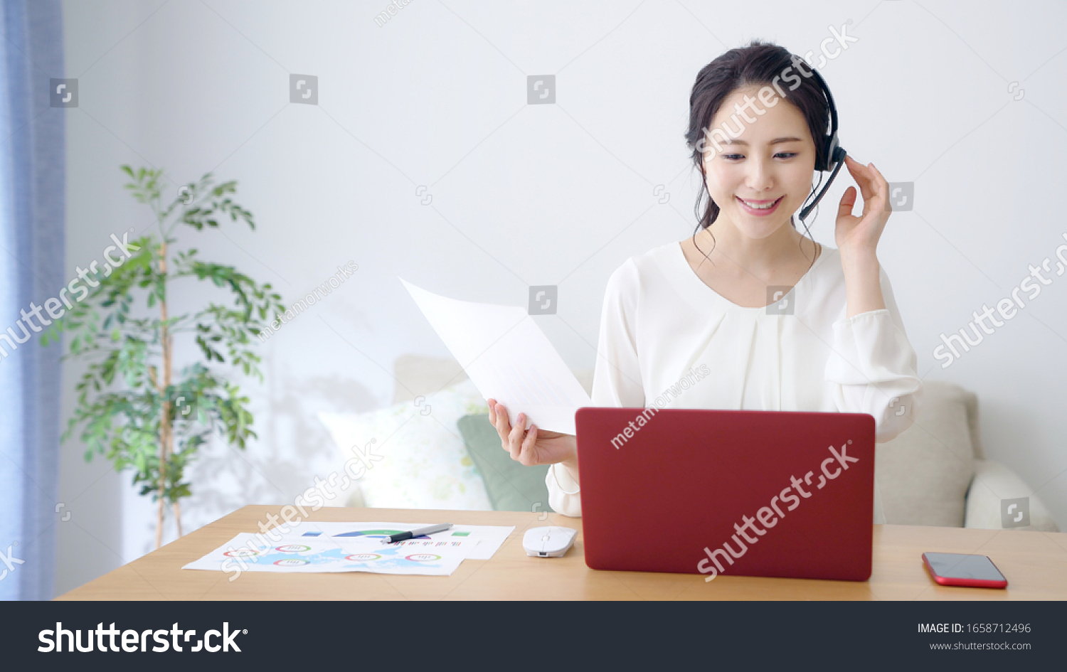Working asian woman in the living room. Telemeeting. Video conference. Remote work. #1658712496