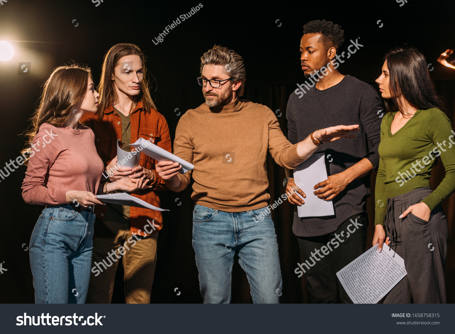 multiethnic actors and actresses rehearsing with theater director on stage #1658758315