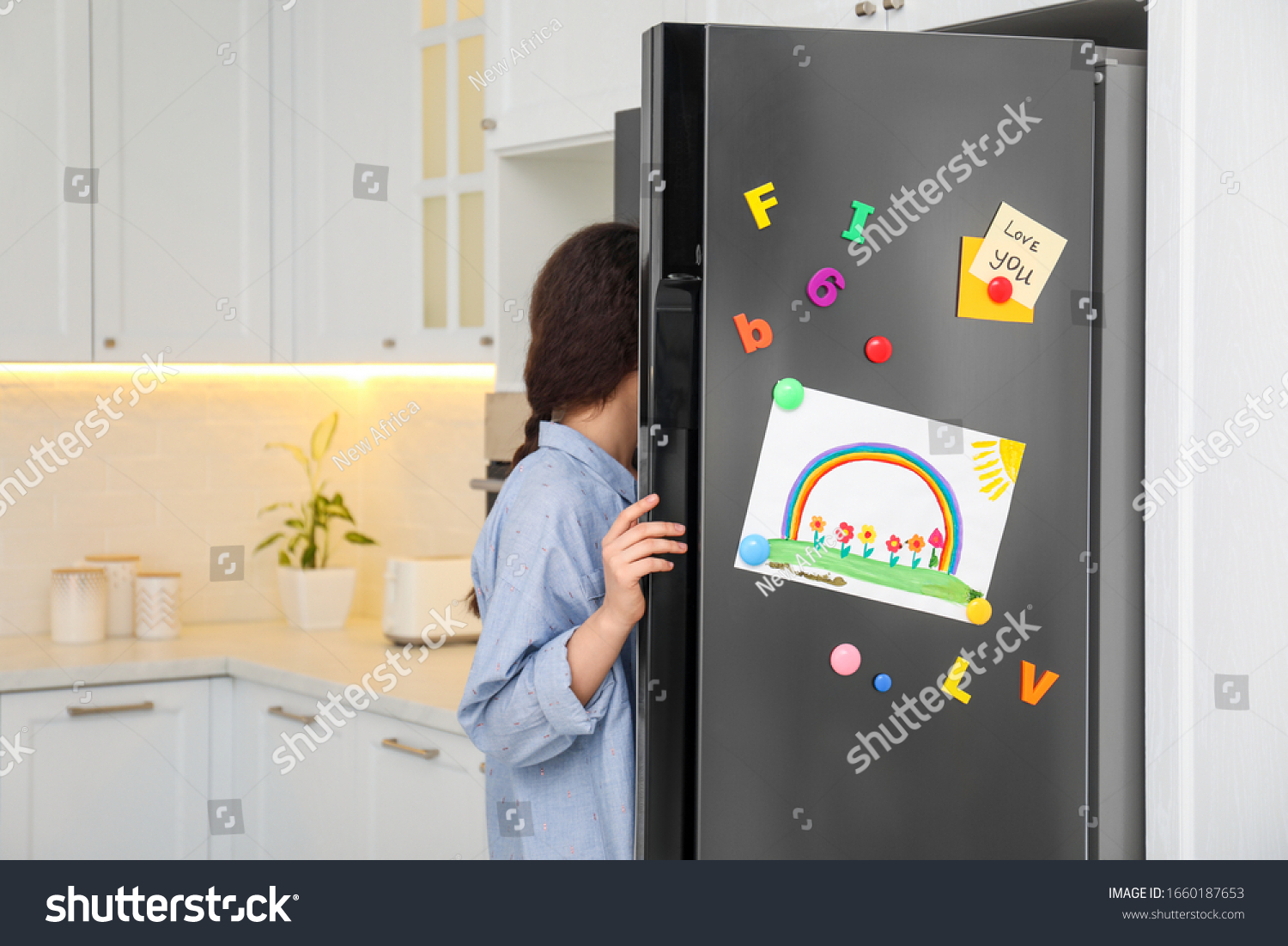 Woman opening refrigerator door with child's drawing, notes and magnets in kitchen #1660187653