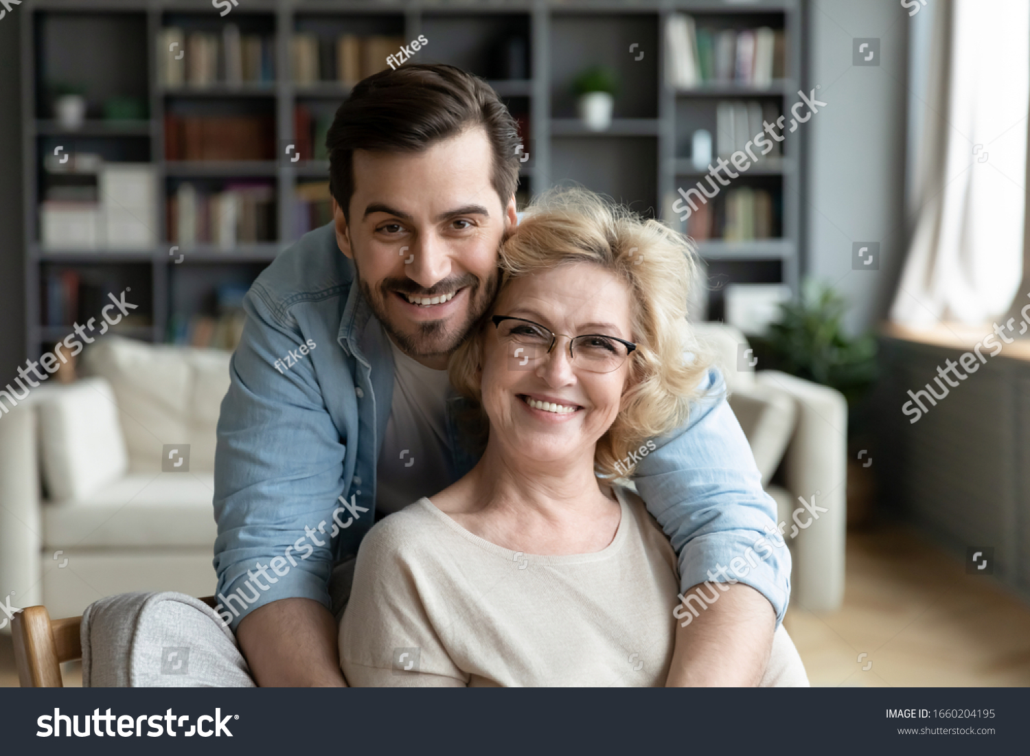 Portrait of grateful adult man hug smiling middle-aged mother show love and care, thankful happy grown-up son in embrace senior 70s mom, enjoy weekend family time at home together, bonding concept #1660204195