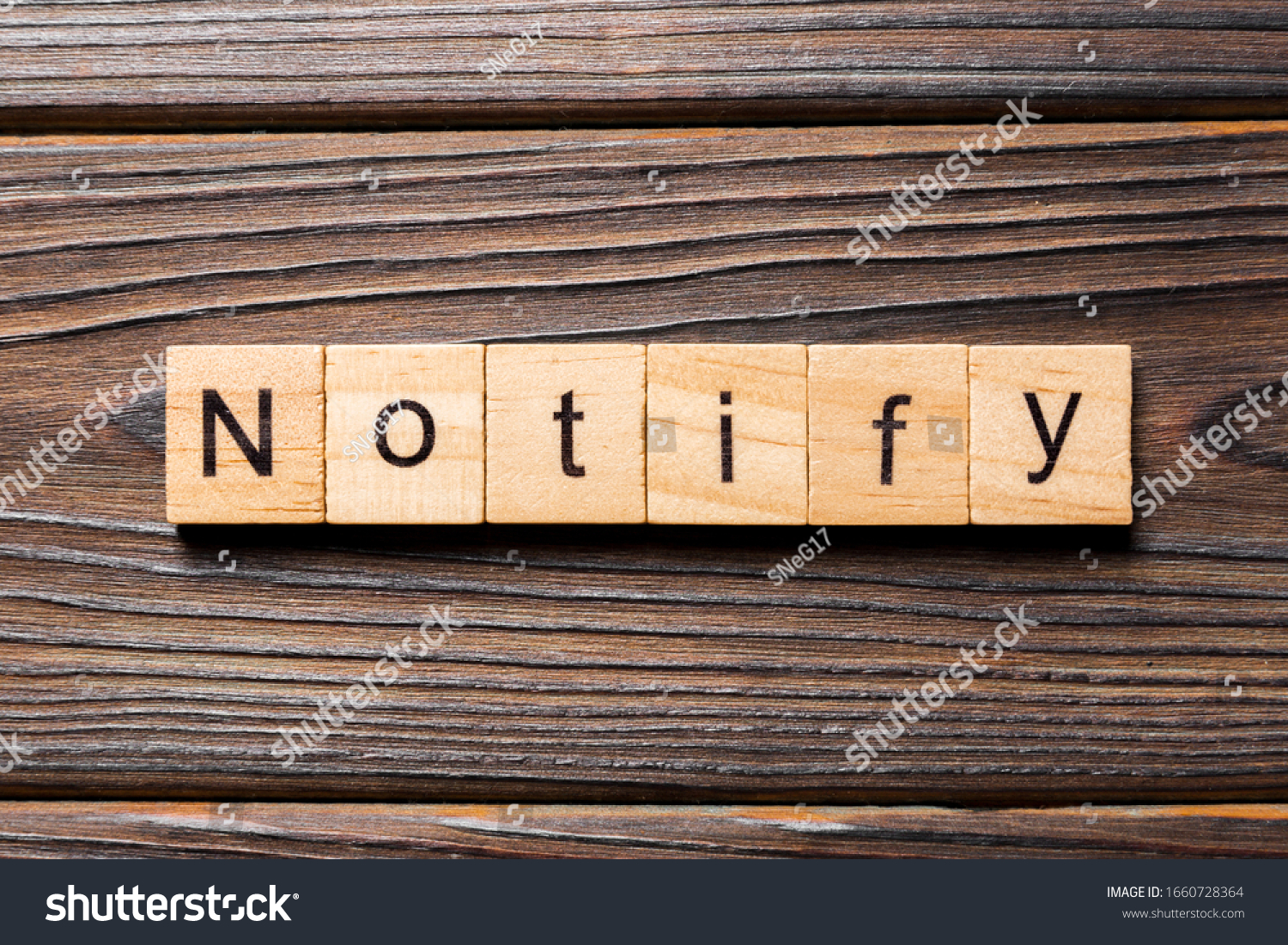 NOTIFY word written on wood block. NOTIFY text on wooden table for your desing, concept. #1660728364
