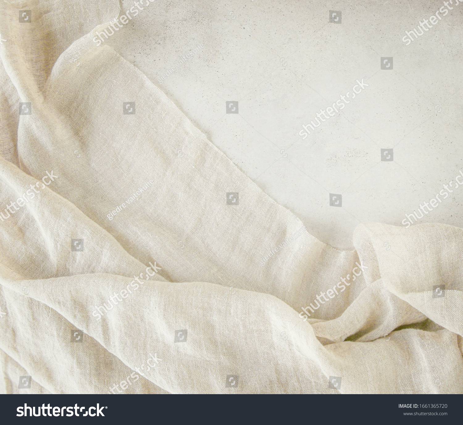 Pure washed linen cloth on light grunge stone background. Natural washed linen fabric on stone tile surface with copy space. #1661365720