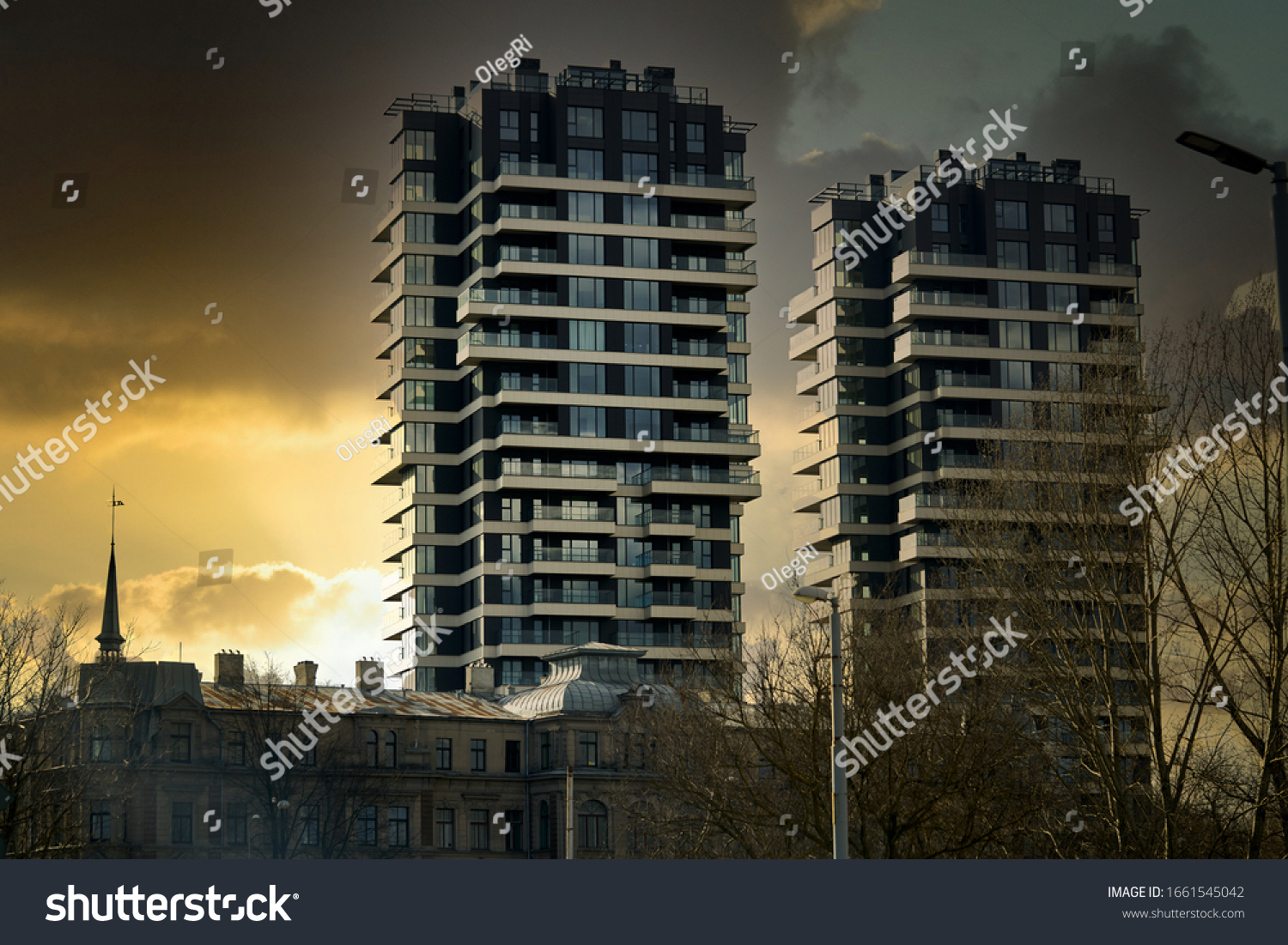 Modern glass building with reflected evening city and sunset sky in it. #1661545042
