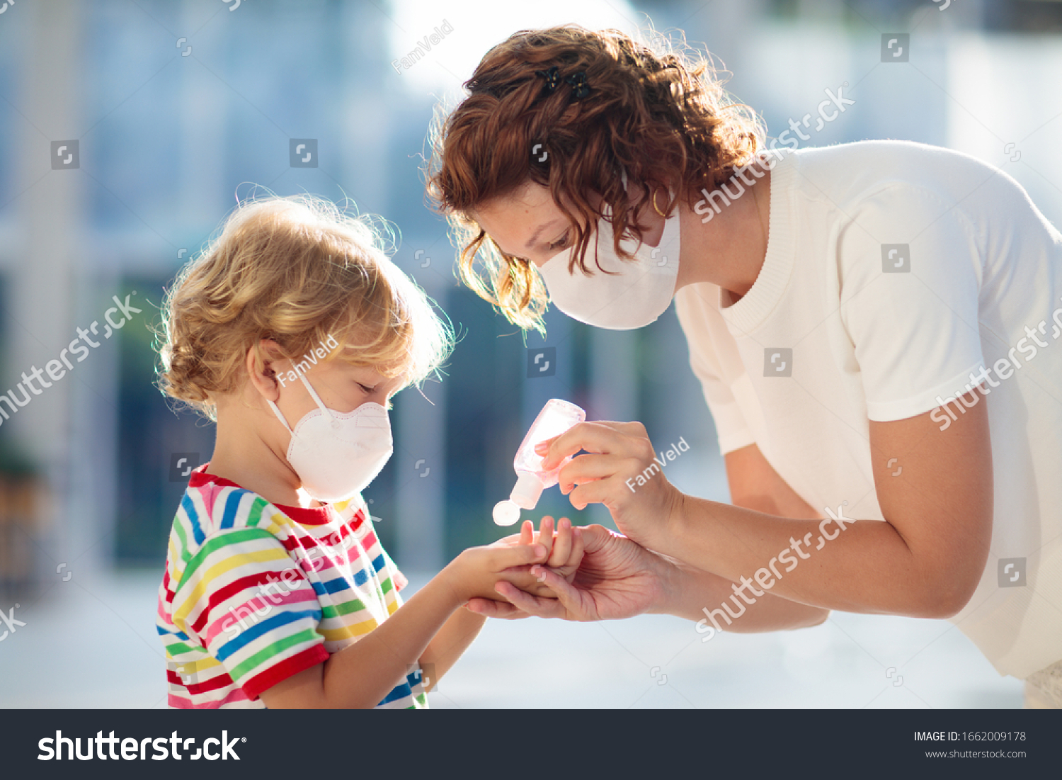 Family with kids in face mask in shopping mall or airport. Mother and child wear facemask during coronavirus and flu outbreak. Virus and illness protection, hand sanitizer in public crowded place. #1662009178
