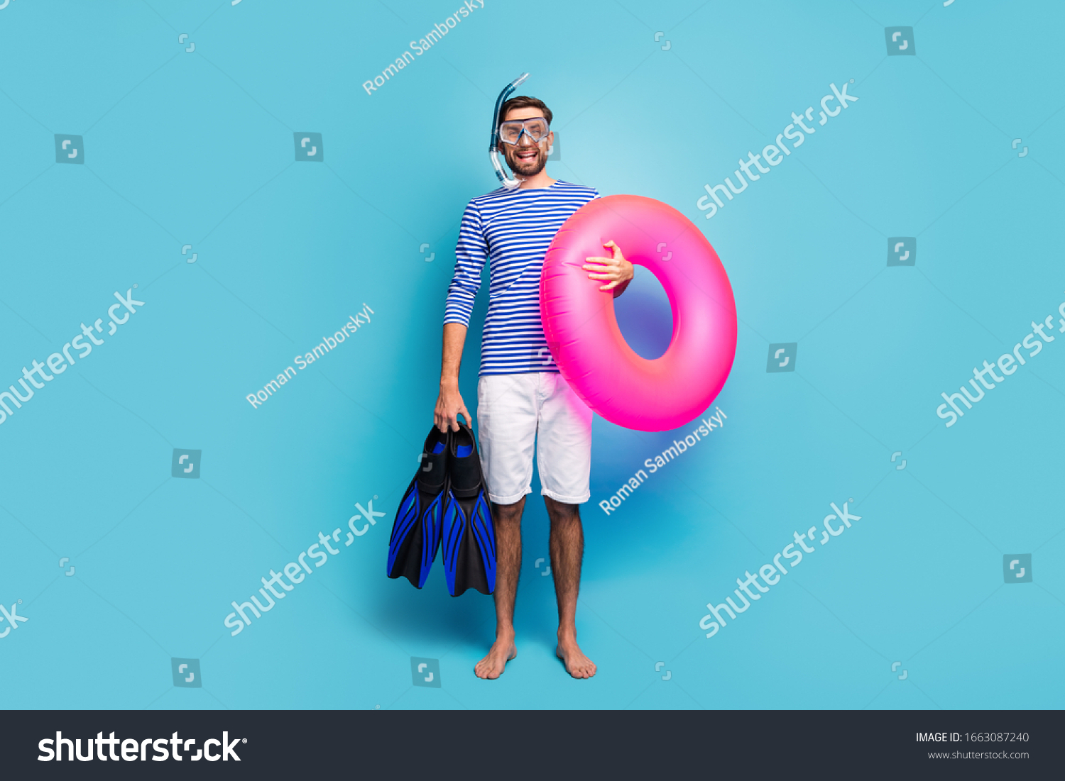 Full body photo of funny excited guy tourist swimmer hold underwater mask breathing tube flippers pink lifebuoy wear striped sailor shirt shorts isolated blue color background #1663087240