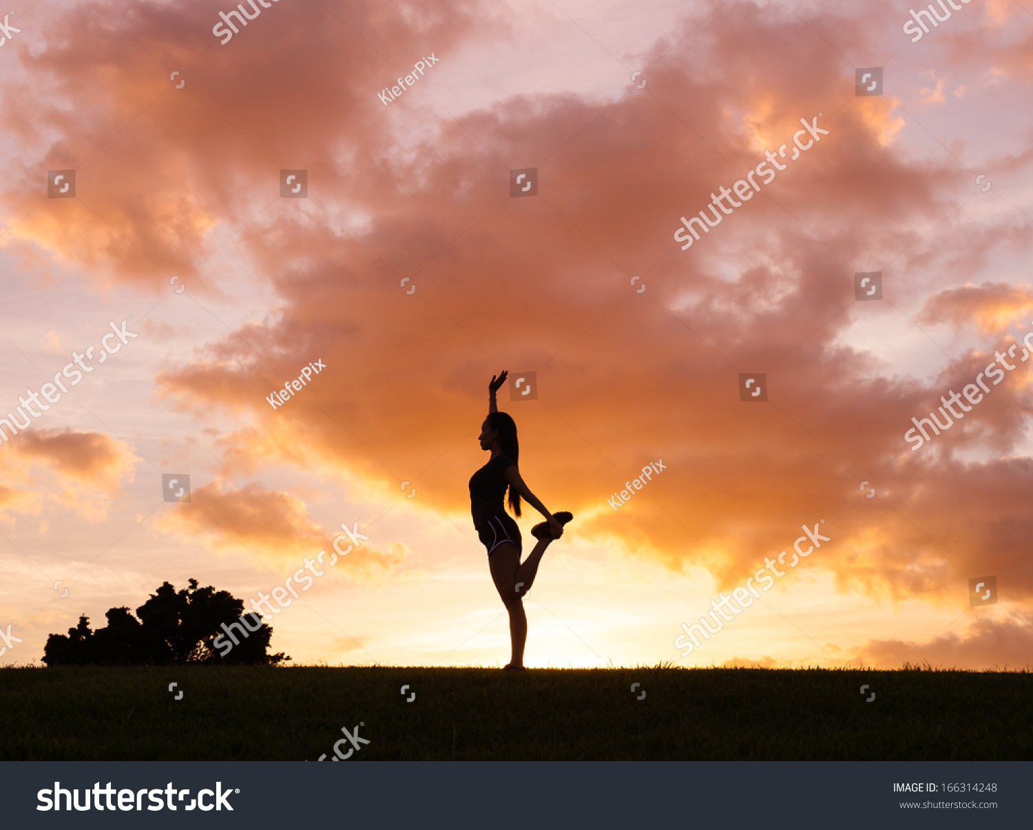 Silhouette of young woman practicing yoga outdoors at sunset #166314248
