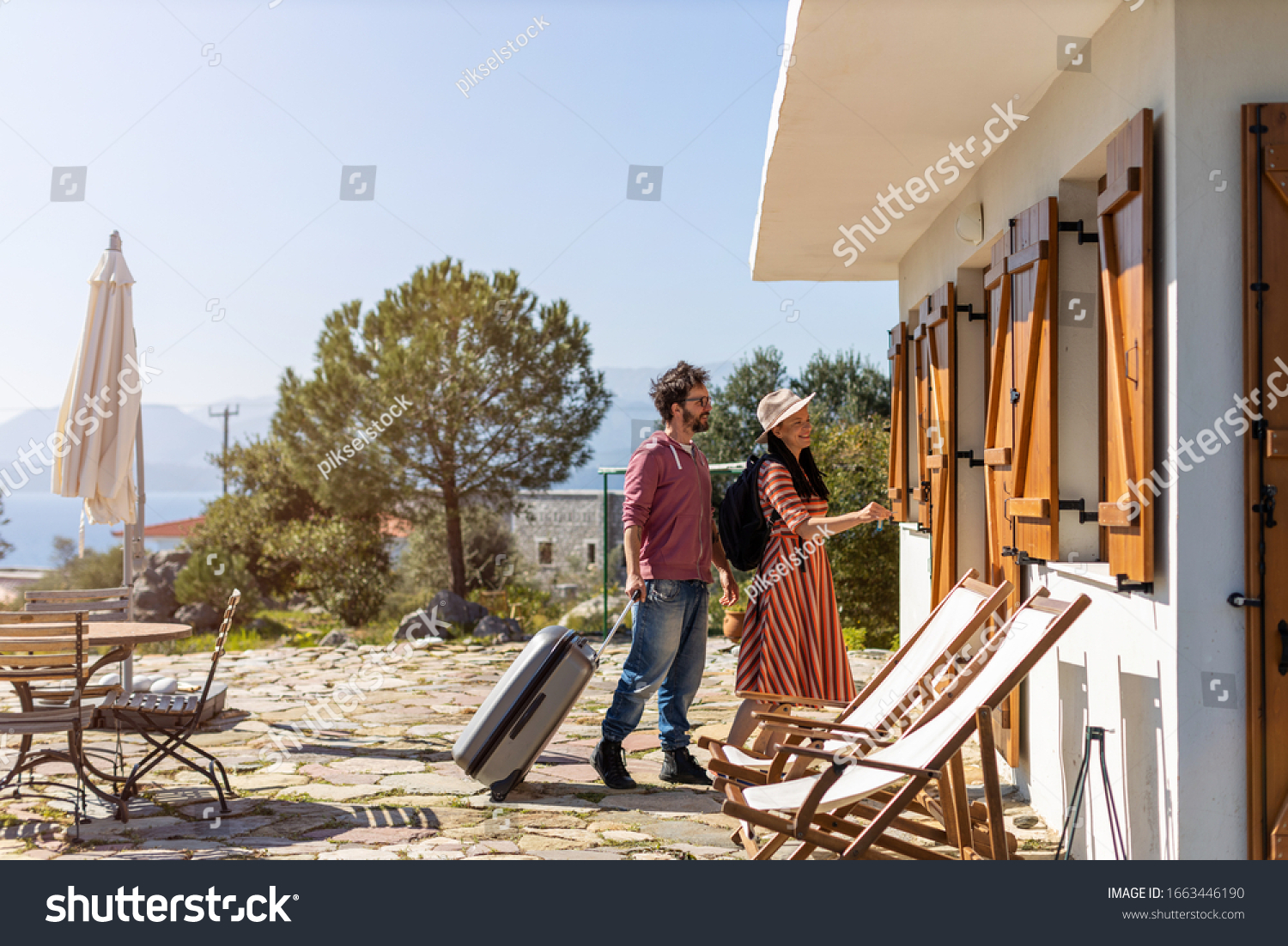 Young couple arriving to at holiday home 
 #1663446190