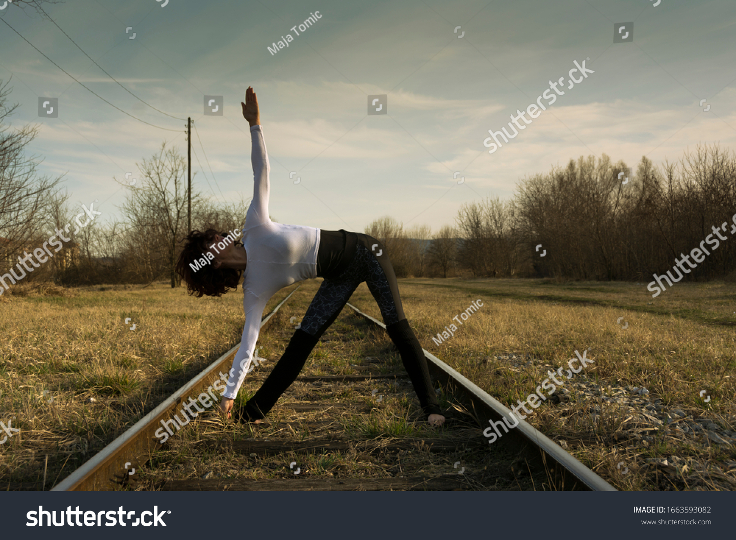 Portrait of  woman practicing yoga  on a abandoned railway in nature #1663593082