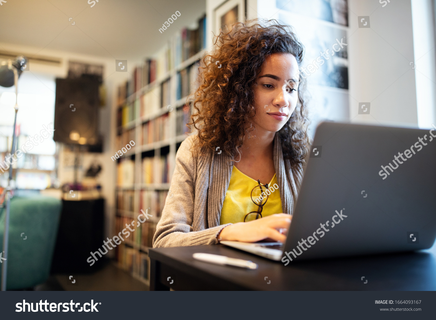 Young beautiful student girl working, learning in college library #1664093167
