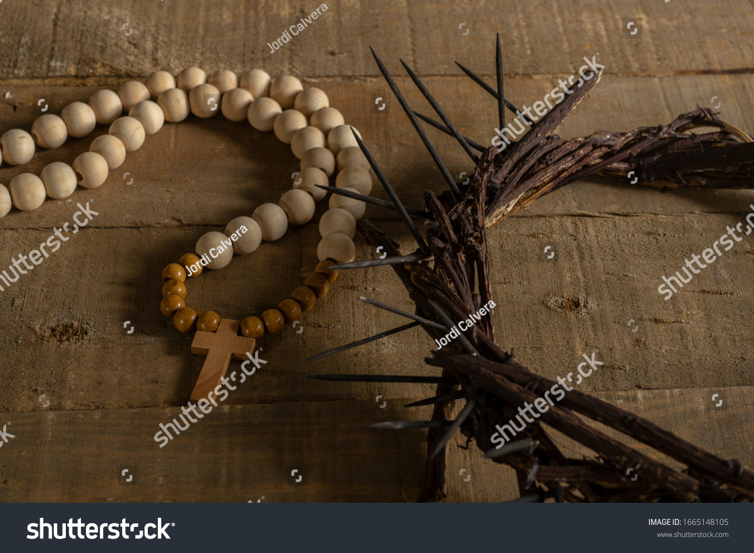 Concept of passion, crucifixion and resurrection. Iconic symbols related to Palm Sunday and Easter rest on a wooden table, crown of thorns and a rosary. #1665148105
