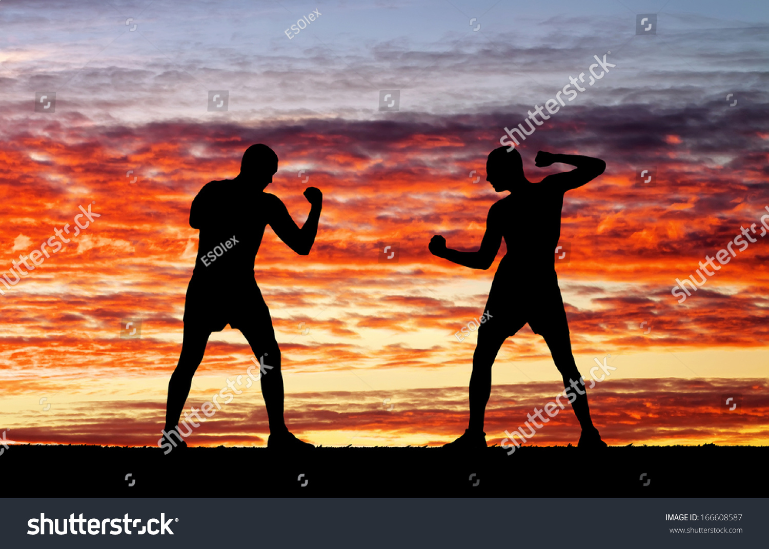 Silhouettes of two fighters on sunset fiery background  #166608587