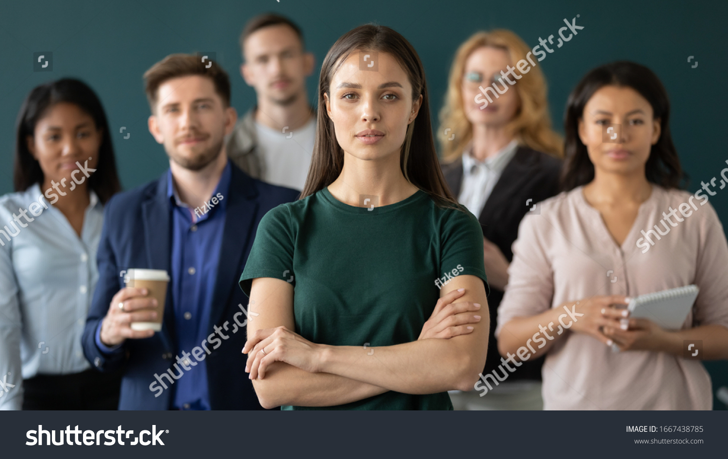 Successful millennial businesswoman stand forefront of multiracial team posing together in office, confident young Caucasian female boss or leader with multiethnic colleagues lawyers at workplace #1667438785