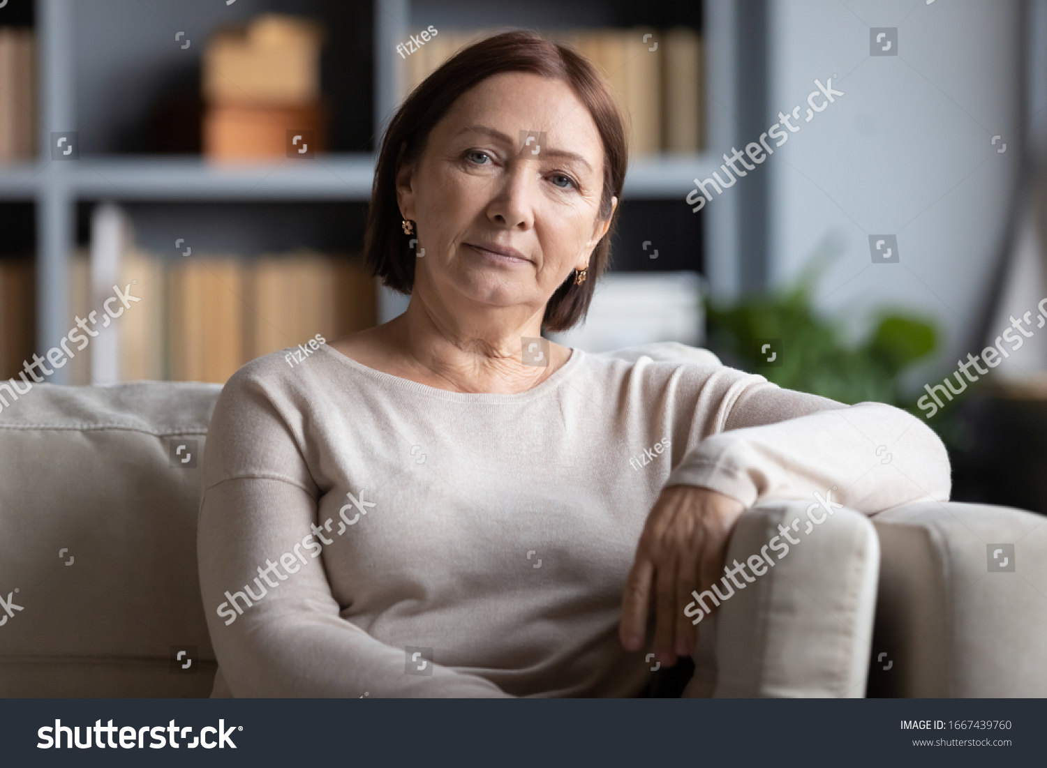 Head shot portrait peaceful tranquil middle aged old woman resting on cozy sofa alone at home. Pleasant happy senior mature 60s grandmother relaxing on couch in living room, posing for photo. #1667439760