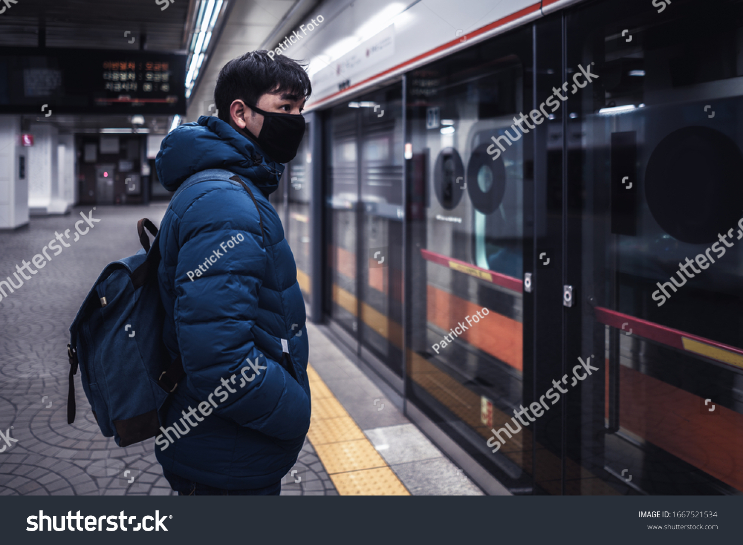 Asian male traveller cover mouth and cough, wear medical face mask to protect from infection of viruses, pandemic, outbreak and epidemic of disease in crowded underground train, Seoul South Korea #1667521534