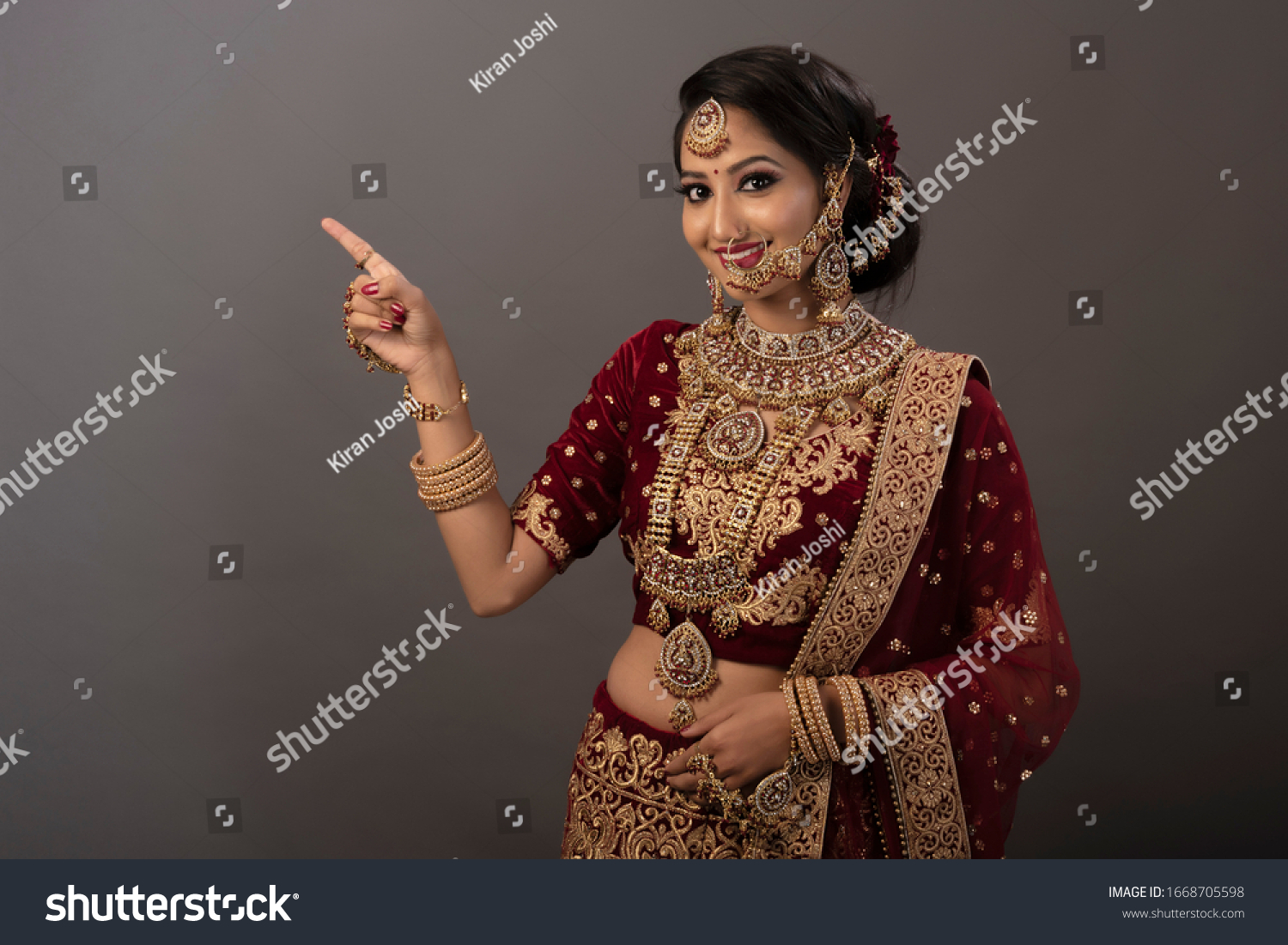 Indian woman with happy expressions and wearing the bridal wear and bridal jewelry #1668705598