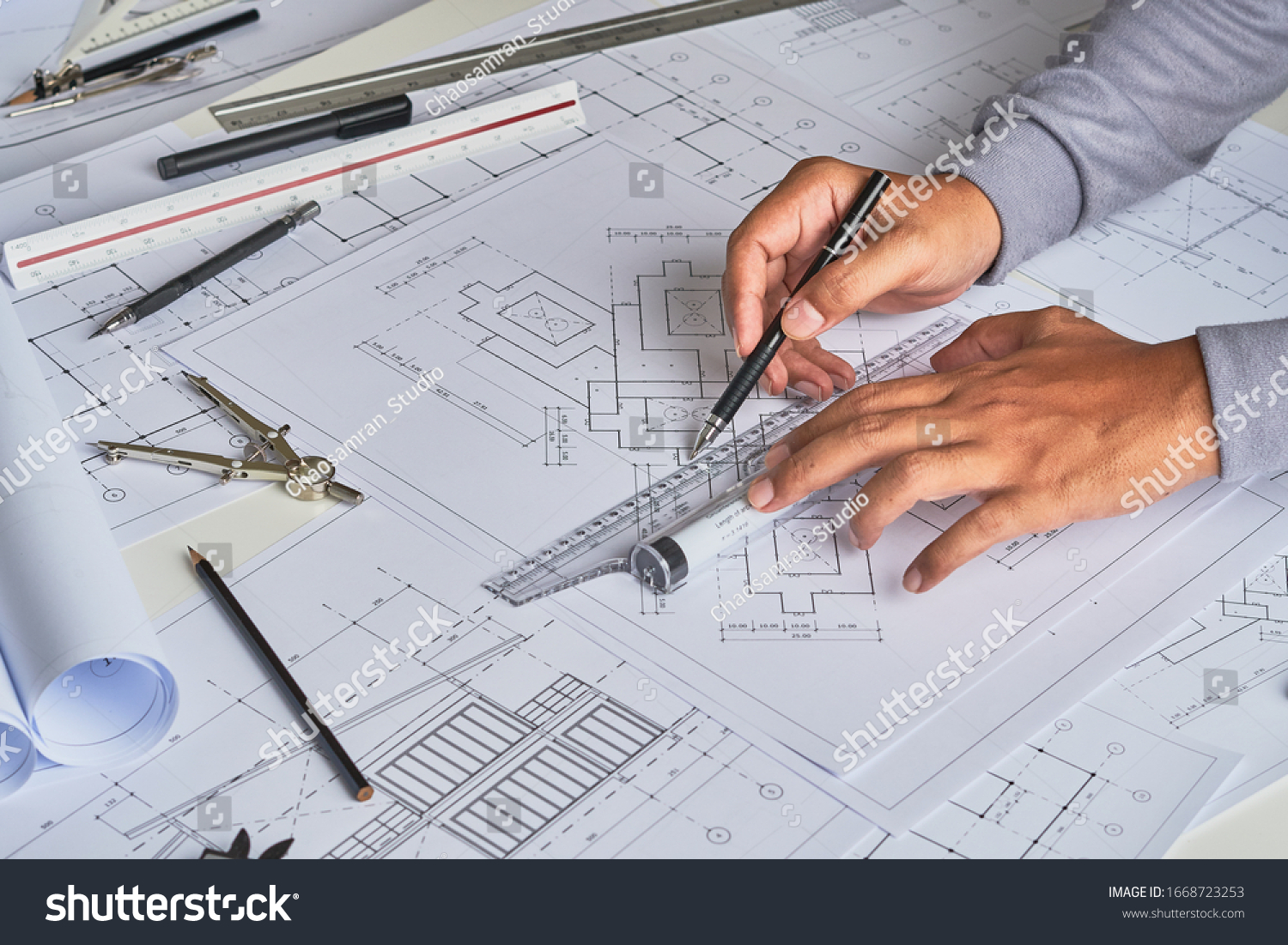 Architect engineer contractor design working drawing sketch plan blueprint and making architectural construction house building in architect studio.                              #1668723253