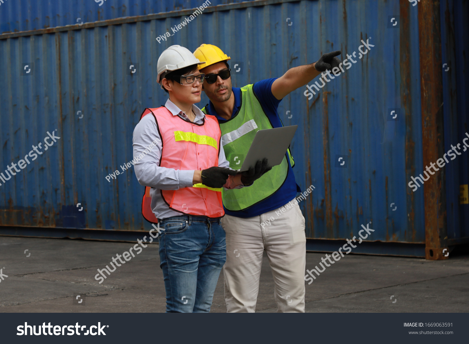 Foreman or Supervisor in uniform and wearing yellow safety helmet checking cargo  from Cargo ship freight for import export with laptop  Business logistic concept. #1669063591