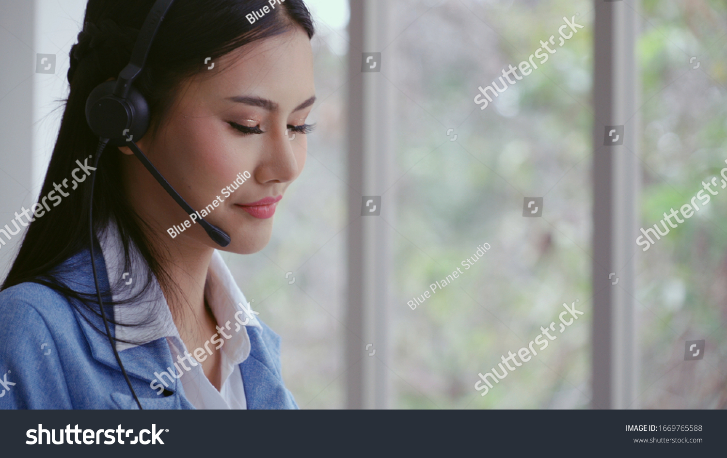 Customer support agent or call center with headset works on desktop computer while supporting the customer on phone call. Operator service business representative concept. #1669765588