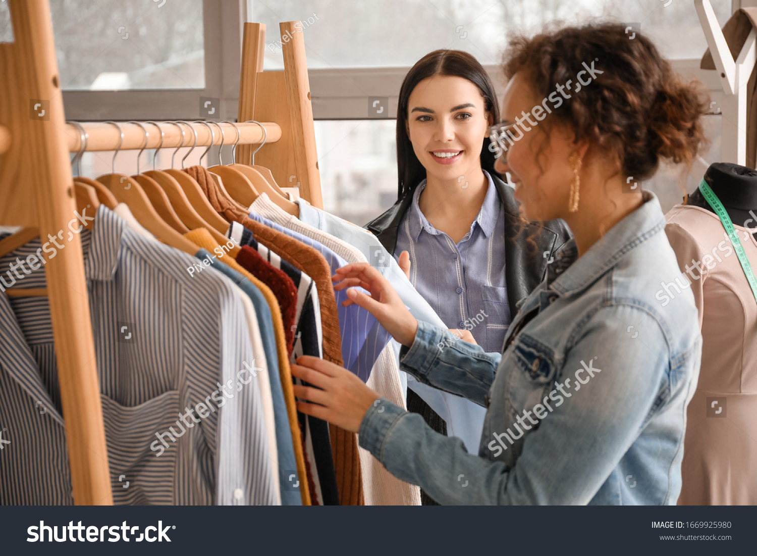 Female clothes stylist with client working in office #1669925980