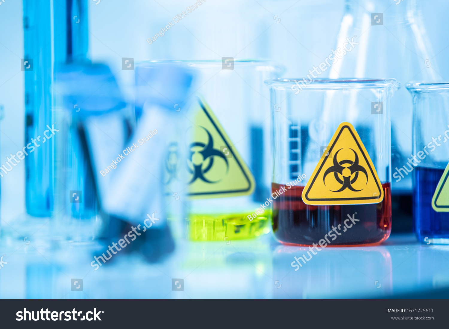 Beaker of sample test, red liquid solution in container with biological hazard warning sticker in laboratory. Idea for science research of contagious disease, virus or other infective pestilence. #1671725611