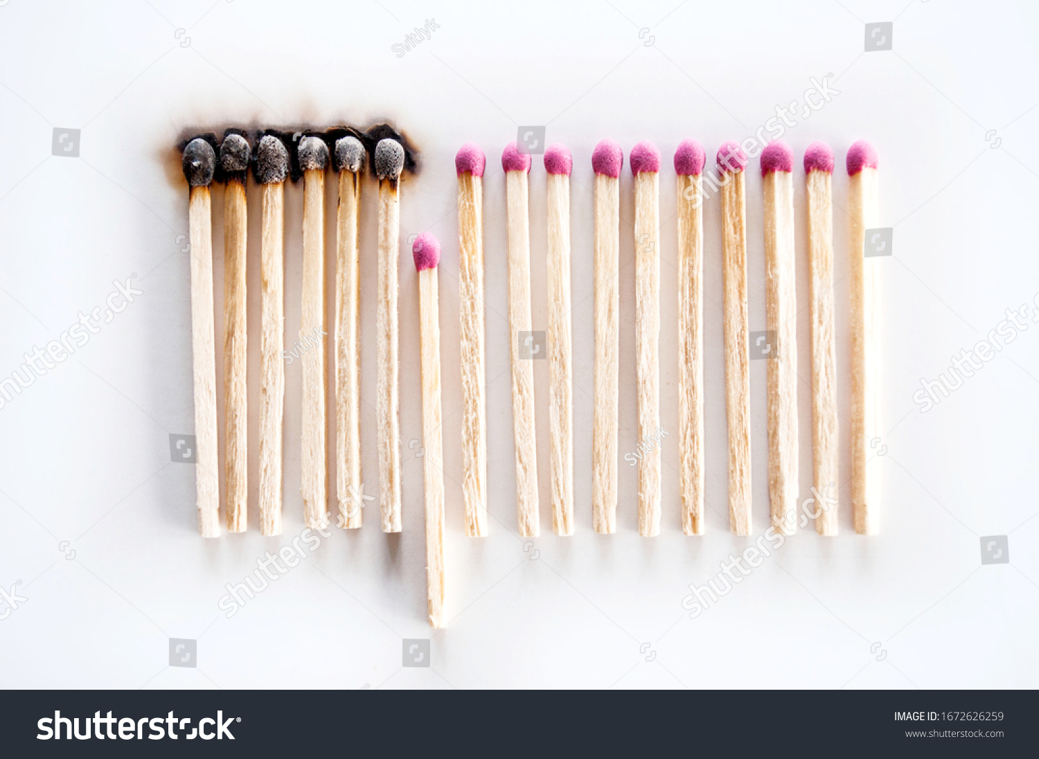 Burnt matches and whole matches on white background. The spread of fire. One whole match isolated to stop the fire. Stop destruction concept #1672626259