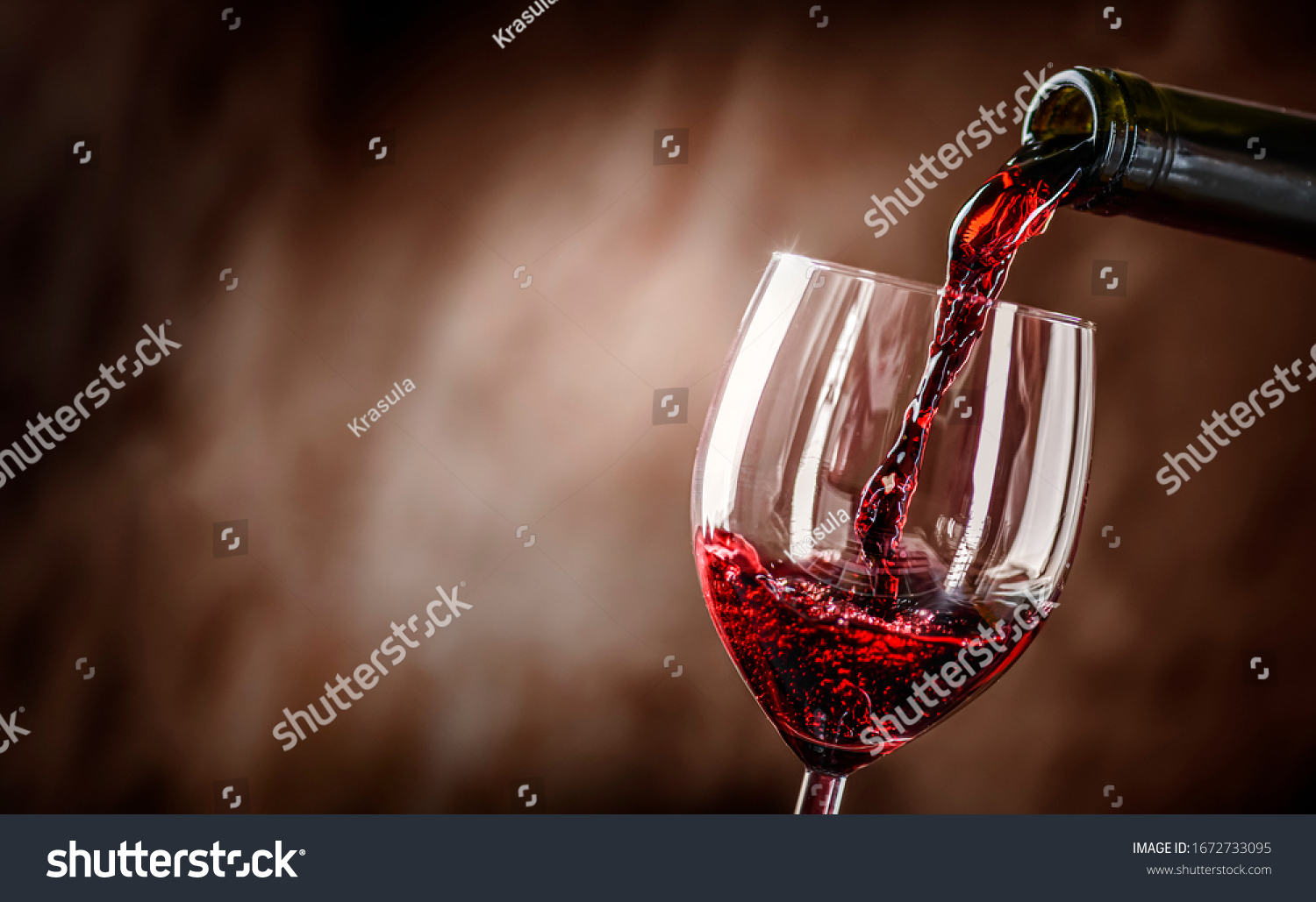 Pouring red wine into the glass against rustic background.  Pour alcohol, winery concept. #1672733095
