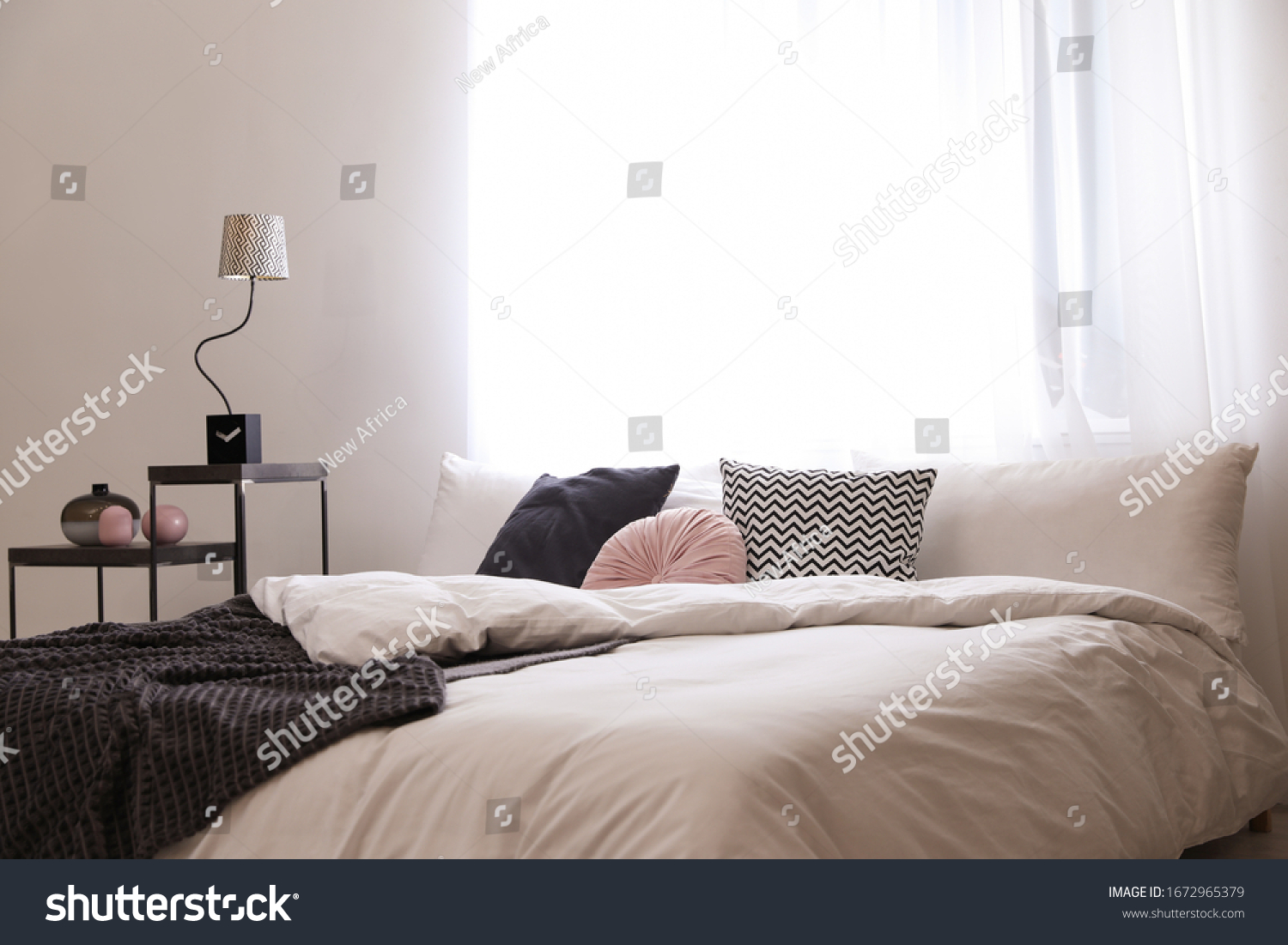 Large comfortable bed in stylish room interior #1672965379