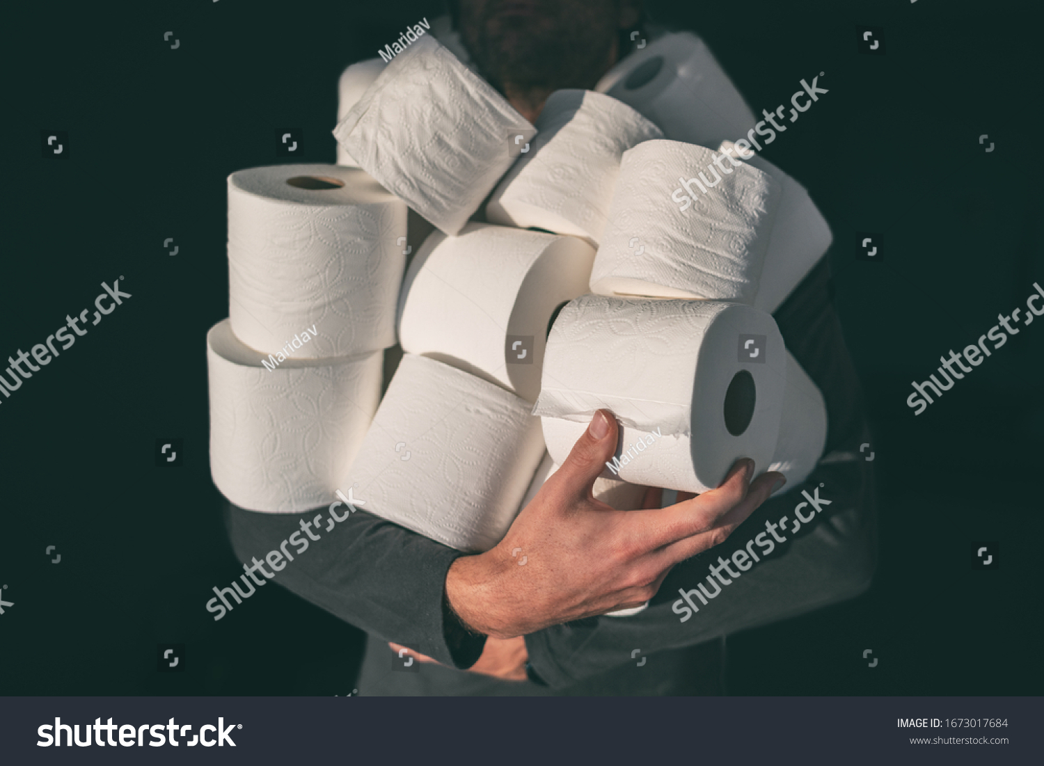 Toilet paper shortage coronavirus panic buying man hoarding carrying many rolls at home in fear of corona virus outbreak closing shopping stores. #1673017684