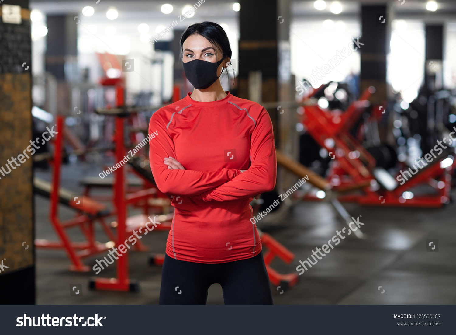 Coronavirus covid-19 prevention, fitness girl with a medical mask posing in gym. Fighting viruses. #1673535187