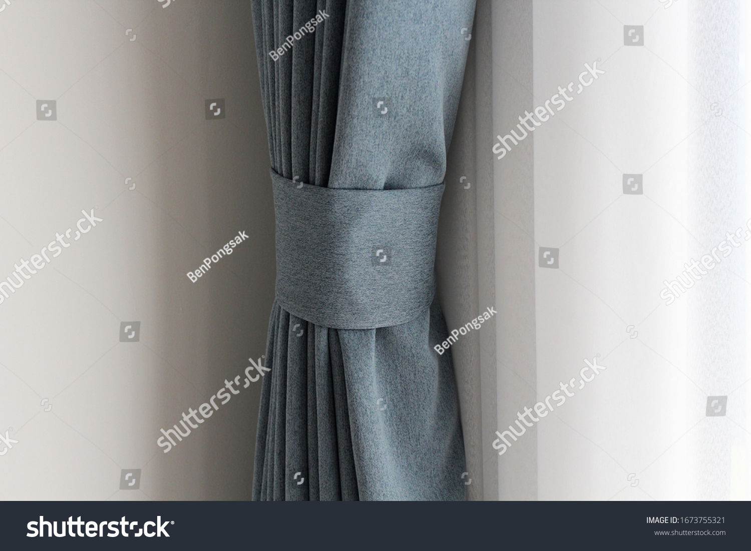 Light blue mix with grey curtain tie back or curtain straps tied the curtain with the white sheer background. Soft and smooth  mood with copy space. Curtains are in ling room. #1673755321