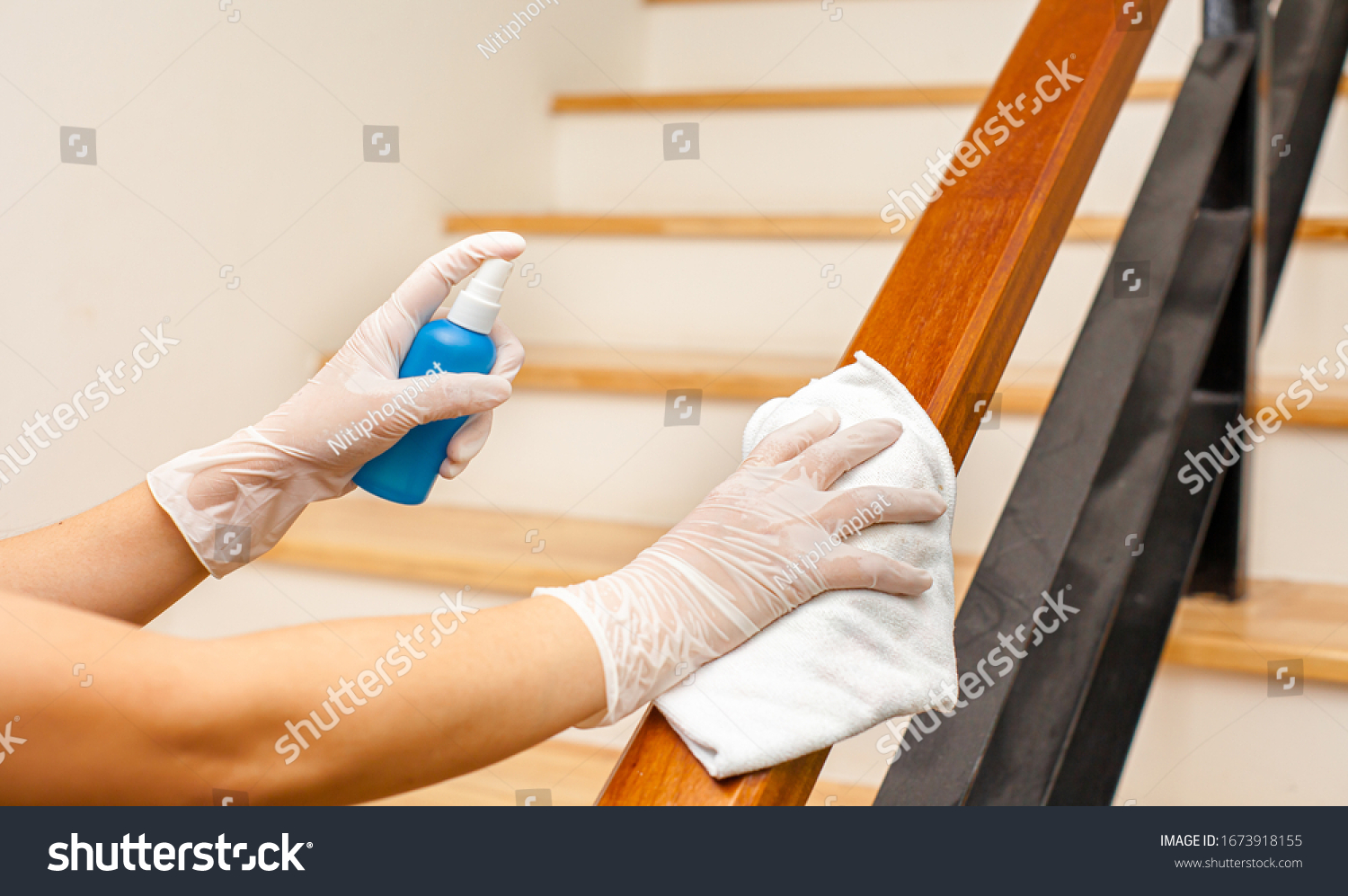 Deep cleaning for Covid-19 disease prevention. alcohol,disinfectant spray on Wipes of Banister in home for safety,infection of Covid-19 virus,contamination,germs,bacteria that are frequently touched . #1673918155